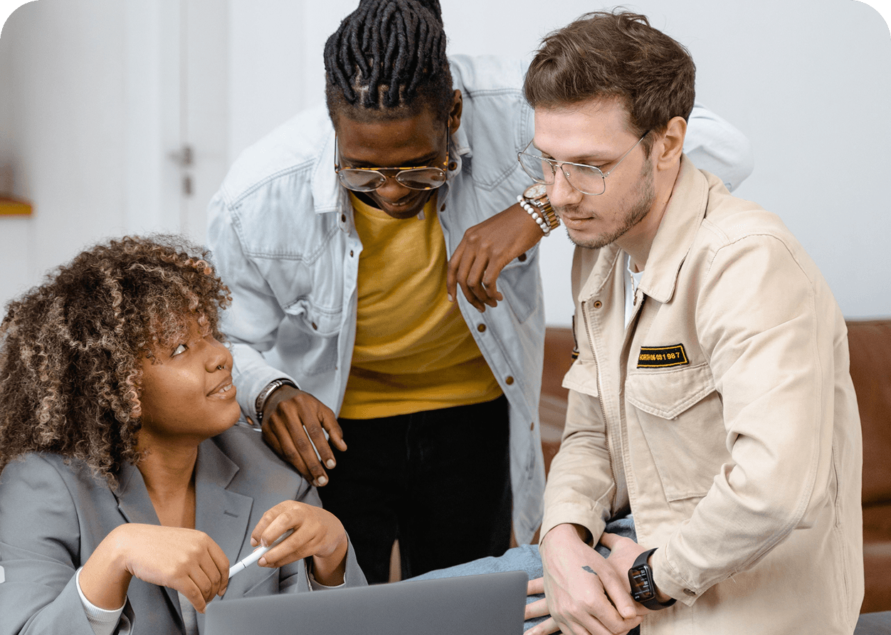 Three community members gathered around a laptop