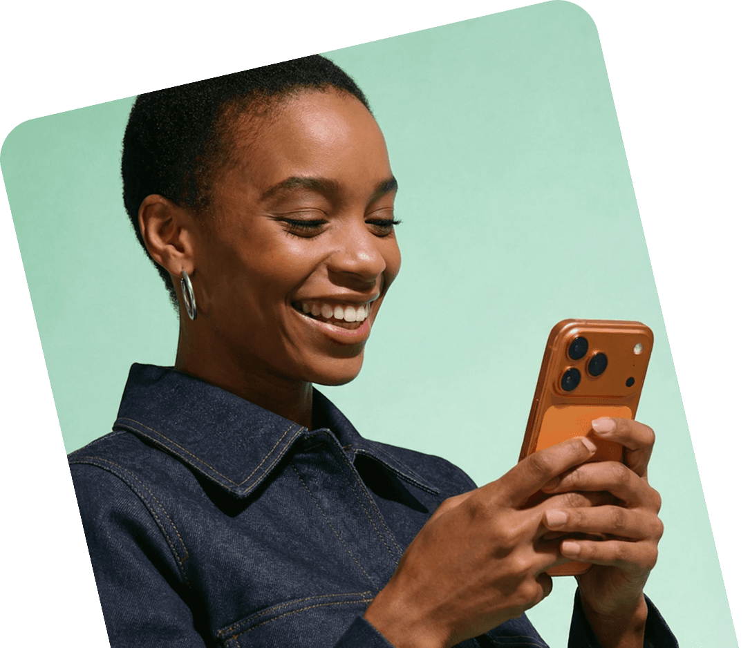A woman smiling at her phone